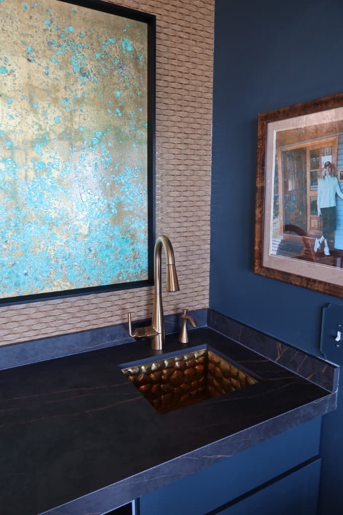 Custom vanity with hammered brass sink and gold faucet